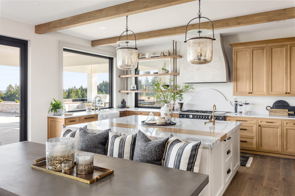 open plan kitchen and diner area in home rustic wooden kitchen cupboards and ceiling beams and a white marble island counter